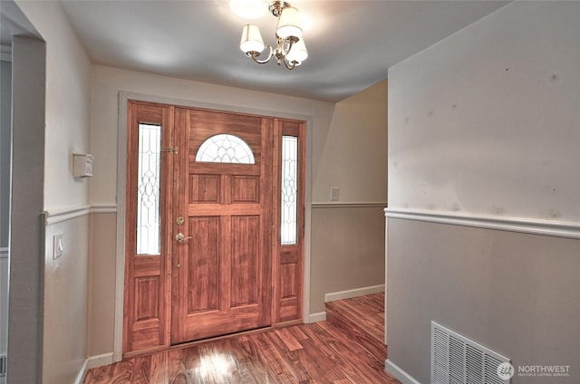 26025 Tronson Rd, Arlington, WA 98223 - entrance foyer featuring wood finished floors, a chandelier, a wainscoted wall, and baseboards