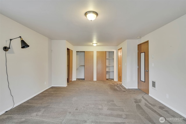 546 Canal Dr NE, Ocean Shores, WA 98569 - unfurnished bedroom with two closets, carpet flooring, and baseboards