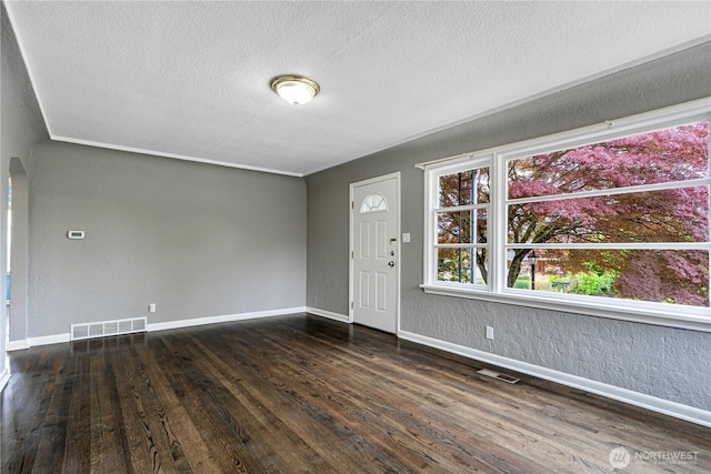 1026 E Guiberson St, Kent, WA 98030 - entrance foyer with dark wood-style flooring, a textured ceiling, baseboards, and arched walkways