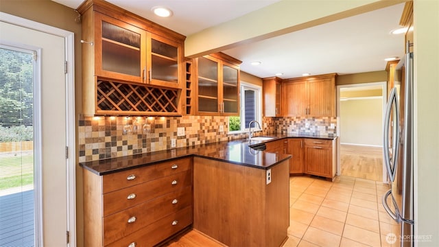1931 237th St SE, Bothell, WA 98021 - kitchen featuring freestanding refrigerator, tasteful backsplash, glass insert cabinets, light tile patterned floors, and brown cabinetry