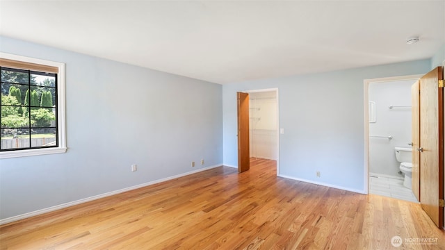 1931 237th St SE, Bothell, WA 98021 - unfurnished bedroom featuring light wood-style floors, a spacious closet, connected bathroom, and a closet