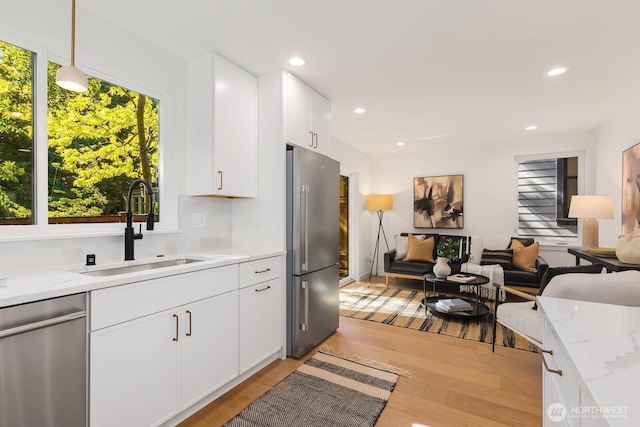 5613 43rd Ave NE, Seattle, WA 98105 - kitchen with appliances with stainless steel finishes, a sink, light wood-type flooring, white cabinetry, and recessed lighting
