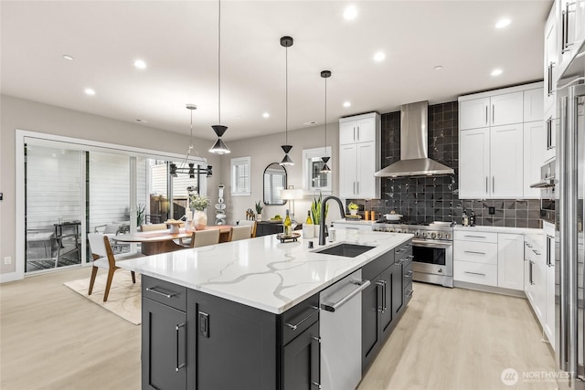 203 8th Ave W, Kirkland, WA 98033 - kitchen with wall chimney range hood, stainless steel appliances, light wood-style flooring, a sink, and recessed lighting