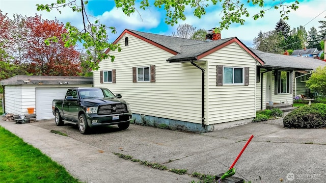2838 SW 106th St, Seattle, WA 98146 - view of home's exterior with an outbuilding, driveway, a chimney, a garage, and roof with shingles