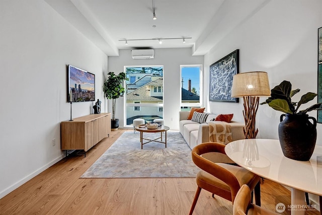 1225 E Roy St, Seattle, WA 98102 - living room with a wall mounted air conditioner, baseboards, and light wood-style floors