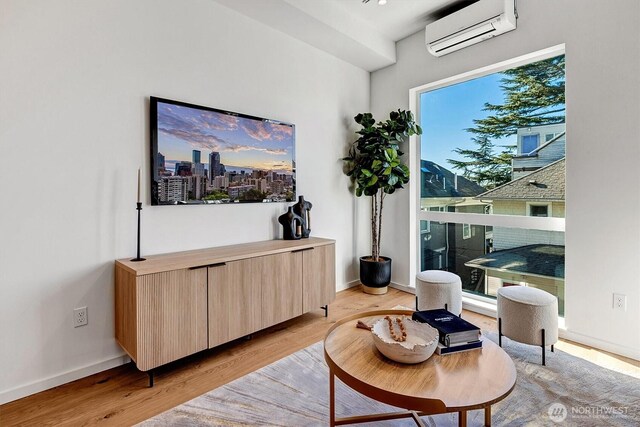 1225 E Roy St, Seattle, WA 98102 - sitting room with an AC wall unit, light wood-type flooring, and baseboards
