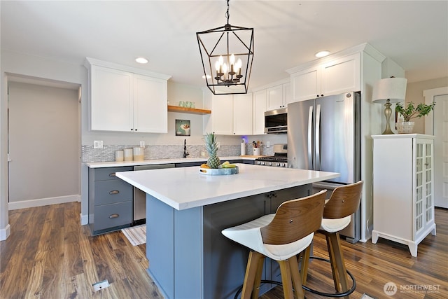 513 I St SW, Tumwater, WA 98512 - kitchen with stainless steel appliances, baseboards, recessed lighting, white cabinetry, and dark wood finished floors