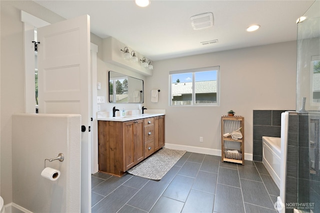 513 I St SW, Tumwater, WA 98512 - bathroom with double vanity, a garden tub, baseboards, and recessed lighting