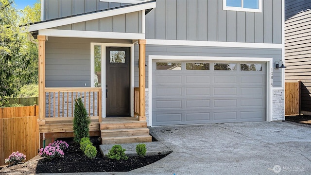10811 Holly Dr Unit C, Everett, WA 98204 - doorway to property with concrete driveway, board and batten siding, an attached garage, and covered porch