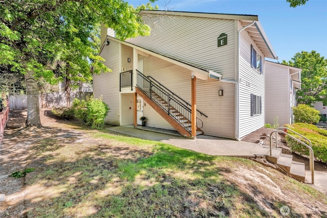 4231 NE 5th St Unit E101, Renton, WA 98059 - rear view of property featuring stairs and a patio area
