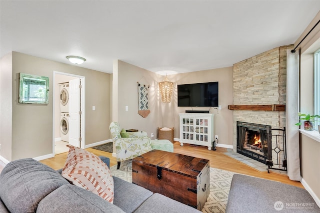4231 NE 5th St Unit E101, Renton, WA 98059 - living area with stacked washer / drying machine, wood finished floors, and a fireplace