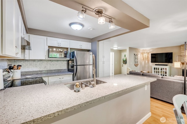 4231 NE 5th St Unit E101, Renton, WA 98059 - kitchen featuring freestanding refrigerator, stove, white cabinetry, light stone counters, and backsplash