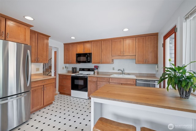 3435 34th Ave W, Seattle, WA 98199 - kitchen with stainless steel appliances, a sink, recessed lighting, a kitchen breakfast bar, and brown cabinetry