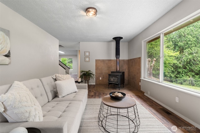 4562 SE Burley Olalla Rd, Olalla, WA 98359 - living area with a textured ceiling, a wood stove, wood finished floors, and baseboards