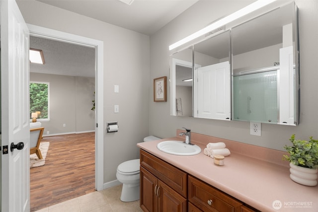 4562 SE Burley Olalla Rd, Olalla, WA 98359 - full bath with vanity, an enclosed shower, toilet, tile patterned floors, and baseboards