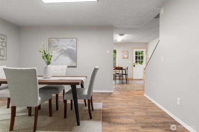 4562 SE Burley Olalla Rd, Olalla, WA 98359 - dining space featuring light wood-type flooring, baseboards, and a textured ceiling