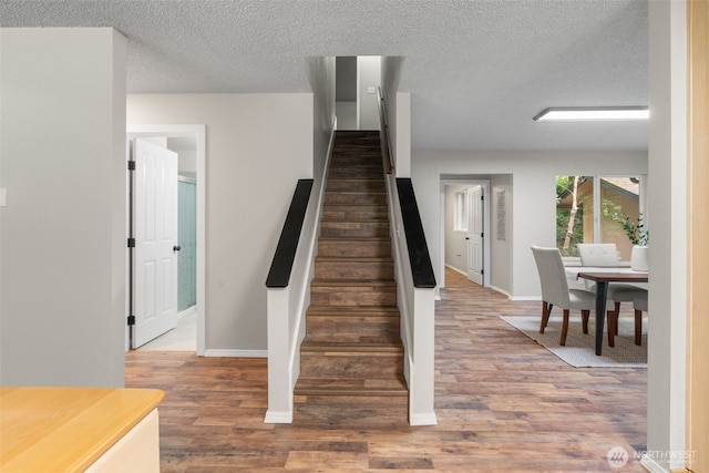 4562 SE Burley Olalla Rd, Olalla, WA 98359 - stairway featuring baseboards, wood finished floors, and a textured ceiling