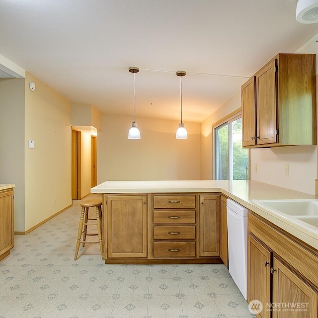 17147 Hope Island Ln, La Conner, WA 98257 - kitchen featuring white dishwasher, a peninsula, light countertops, and brown cabinetry