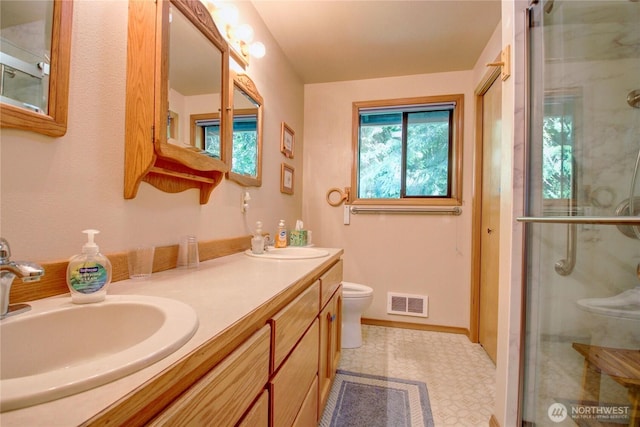 17147 Hope Island Ln, La Conner, WA 98257 - bathroom with double vanity, toilet, a shower stall, and tile patterned floors