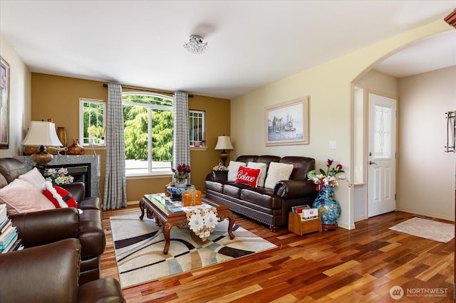1440 Allyn Ln, Oak Harbor, WA 98277 - living room with arched walkways, wood finished floors, a fireplace, and baseboards