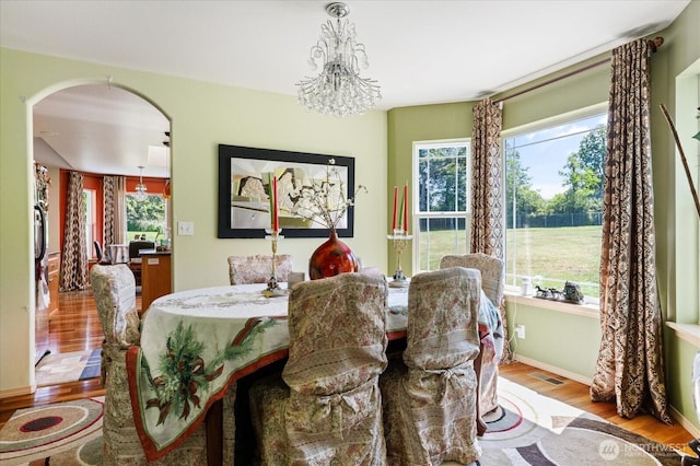 1440 Allyn Ln, Oak Harbor, WA 98277 - dining area with arched walkways, wood finished floors, a chandelier, and baseboards