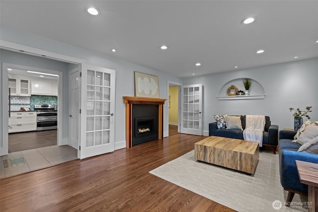 1716 N 125th St, Seattle, WA 98133 - living area featuring french doors, wood finished floors, recessed lighting, and a lit fireplace
