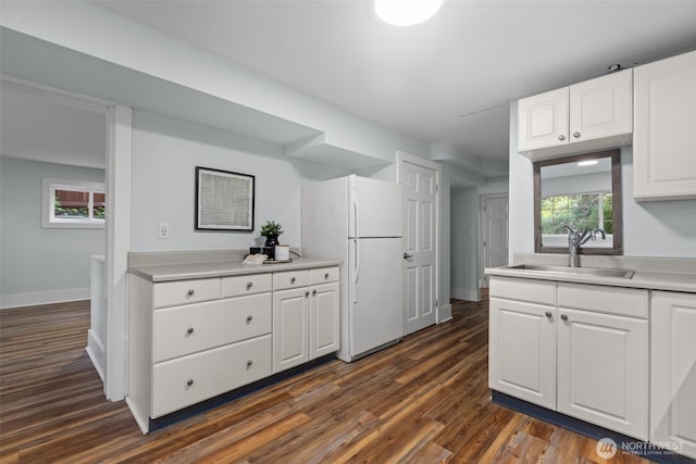1716 N 125th St, Seattle, WA 98133 - kitchen with freestanding refrigerator, dark wood finished floors, white cabinets, and light countertops