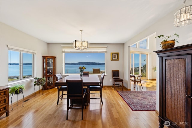2364 Strawberry Point Rd, Oak Harbor, WA 98277 - dining space featuring a chandelier, light wood-style floors, and baseboards