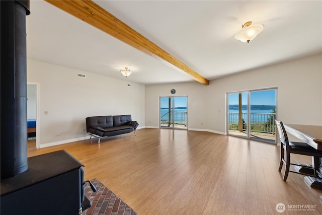 2364 Strawberry Point Rd, Oak Harbor, WA 98277 - living area with a wood stove, plenty of natural light, beam ceiling, and wood finished floors