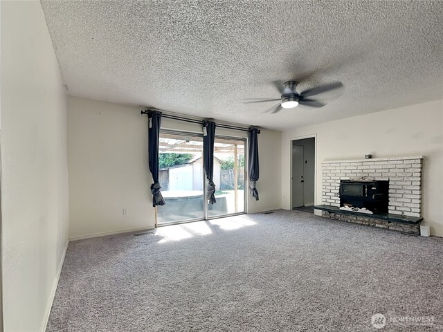 17103 15th Ave E, Spanaway, WA 98387 - unfurnished living room with ceiling fan, carpet floors, a textured ceiling, baseboards, and a brick fireplace