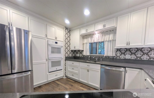 201 Union Ave SE Unit 188, Renton, WA 98059 - kitchen featuring appliances with stainless steel finishes, a sink, white cabinetry, dark countertops, and dark wood-style flooring