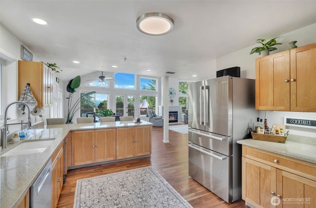 521 E Enchantment Dr, Union, WA 98592 - kitchen with a sink, appliances with stainless steel finishes, ceiling fan, a glass covered fireplace, and light wood finished floors