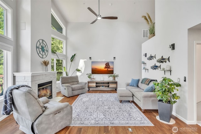 521 E Enchantment Dr, Union, WA 98592 - living room with high vaulted ceiling, a ceiling fan, a fireplace, wood finished floors, and baseboards