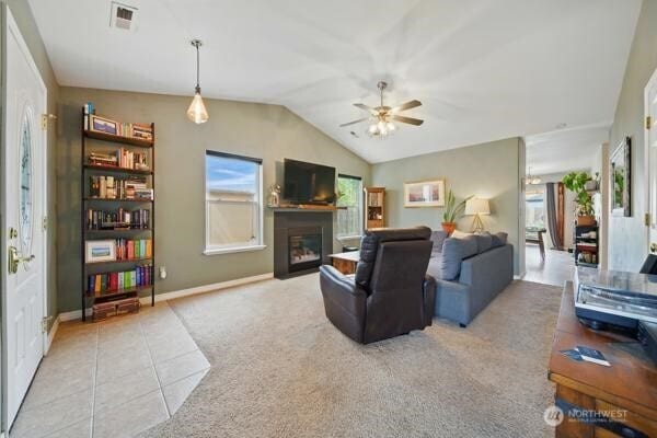 252 NW Ruby Ln, College Place, WA 99324 - tiled living room featuring a ceiling fan, vaulted ceiling, a glass covered fireplace, carpet, and baseboards