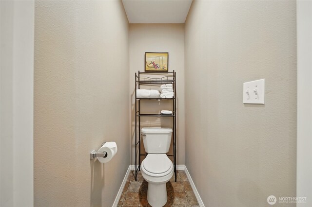 252 NW Ruby Ln, College Place, WA 99324 - bathroom featuring baseboards, toilet, and stone finish flooring