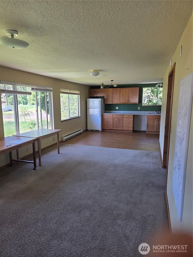 12749 Ranger Rd, Leavenworth, WA 98826 - kitchen featuring freestanding refrigerator, a baseboard heating unit, dark carpet, a textured ceiling, and a sink