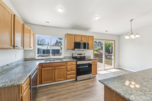 324 E 48th Street Dr, Tacoma, WA 98404 - kitchen featuring appliances with stainless steel finishes, a sink, a chandelier, pendant lighting, and light wood-type flooring