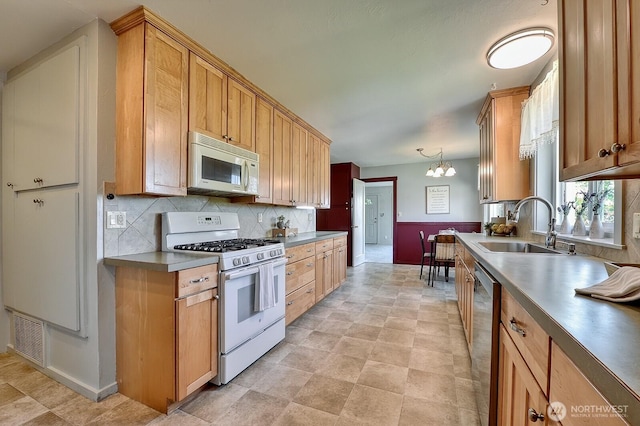 1160 St Paul St, Bellingham, WA 98229 - kitchen with white appliances, a sink, baseboards, tasteful backsplash, and a chandelier