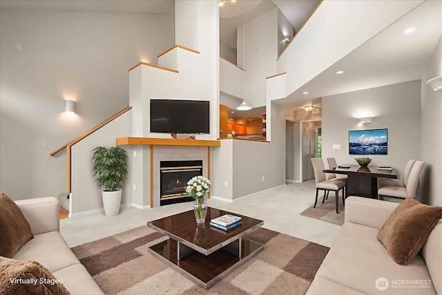 9008 NE 54th St Unit A3, Vancouver, WA 98662 - living room featuring carpet, stairway, a tiled fireplace, and a high ceiling