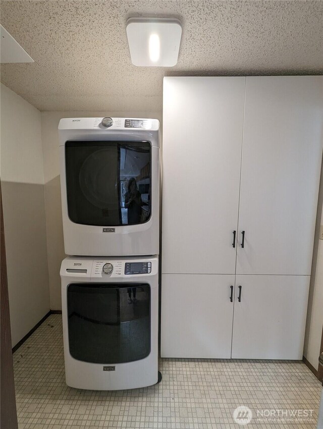 24 Nancy Ln, Copalis Beach, WA 98535 - laundry area with stacked washer / dryer, a textured ceiling, and tile patterned flooring