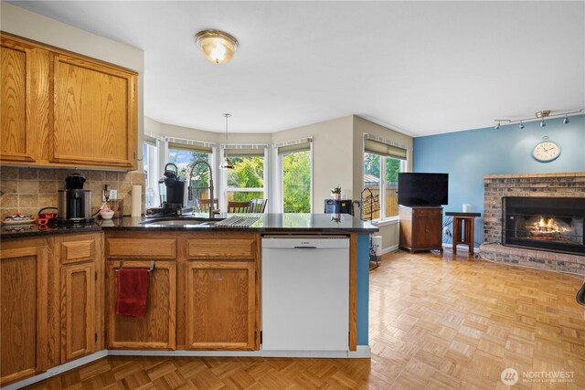 972 Rose Pl, Buckley, WA 98321 - kitchen with dishwasher, a sink, dark countertops, brown cabinets, and a fireplace