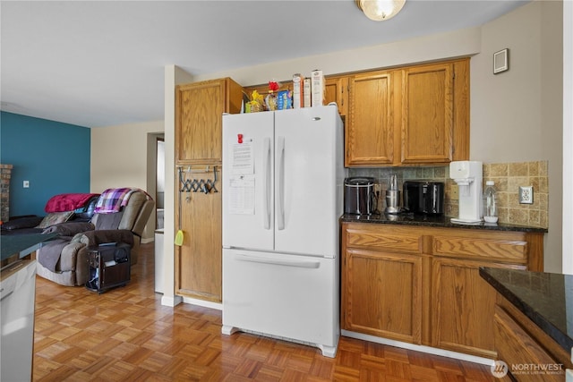 972 Rose Pl, Buckley, WA 98321 - kitchen with freestanding refrigerator, brown cabinetry, decorative backsplash, dark stone countertops, and open floor plan