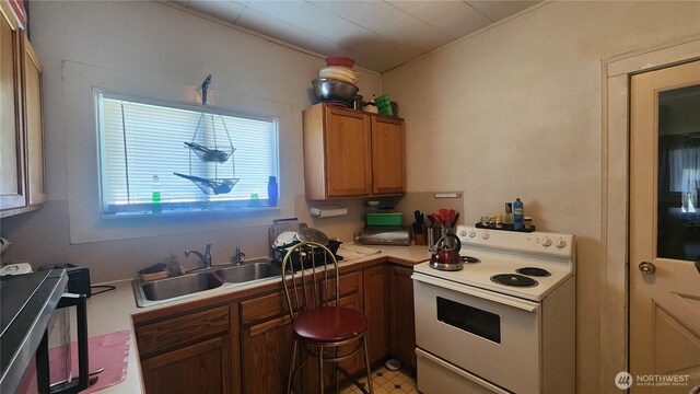 2215 Cherry St, Hoquiam, WA 98550 - kitchen featuring white range with electric cooktop, light countertops, brown cabinetry, and ornamental molding