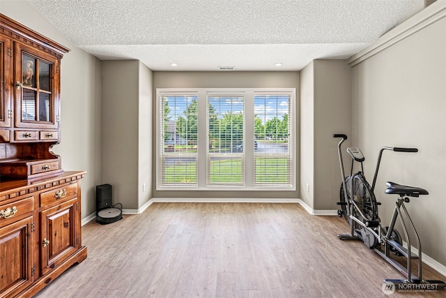 2321 52nd Ave, Longview, WA 98632 - exercise room featuring a textured ceiling, light wood finished floors, and baseboards