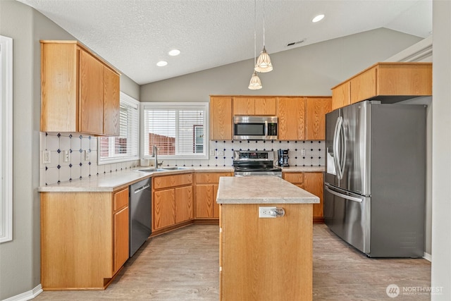 2321 52nd Ave, Longview, WA 98632 - kitchen featuring appliances with stainless steel finishes, vaulted ceiling, a sink, tasteful backsplash, and a kitchen island