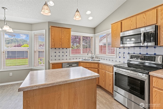 2321 52nd Ave, Longview, WA 98632 - kitchen with stainless steel appliances, a sink, light wood-style flooring, decorative backsplash, and a textured ceiling