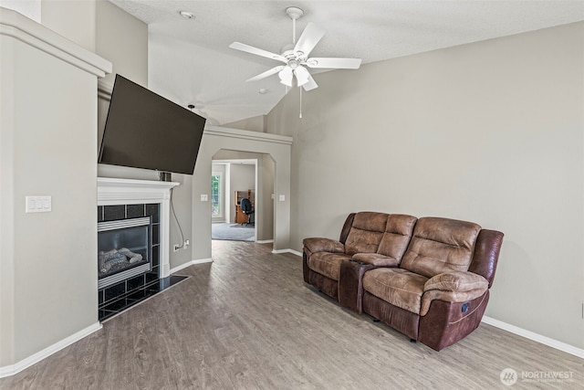 2321 52nd Ave, Longview, WA 98632 - living room with wood finished floors, ceiling fan, a tiled fireplace, lofted ceiling, and baseboards