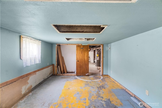 504 W 4th St, Aberdeen, WA 98520 - spare room featuring electric water heater and a textured ceiling