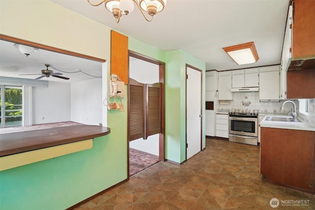 32427 6th Ave, Black Diamond, WA 98010 - kitchen with stainless steel range oven, a sink, under cabinet range hood, white cabinets, and decorative backsplash