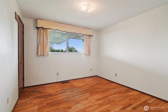 32427 6th Ave, Black Diamond, WA 98010 - unfurnished room with light wood-style floors, a textured ceiling, and baseboards